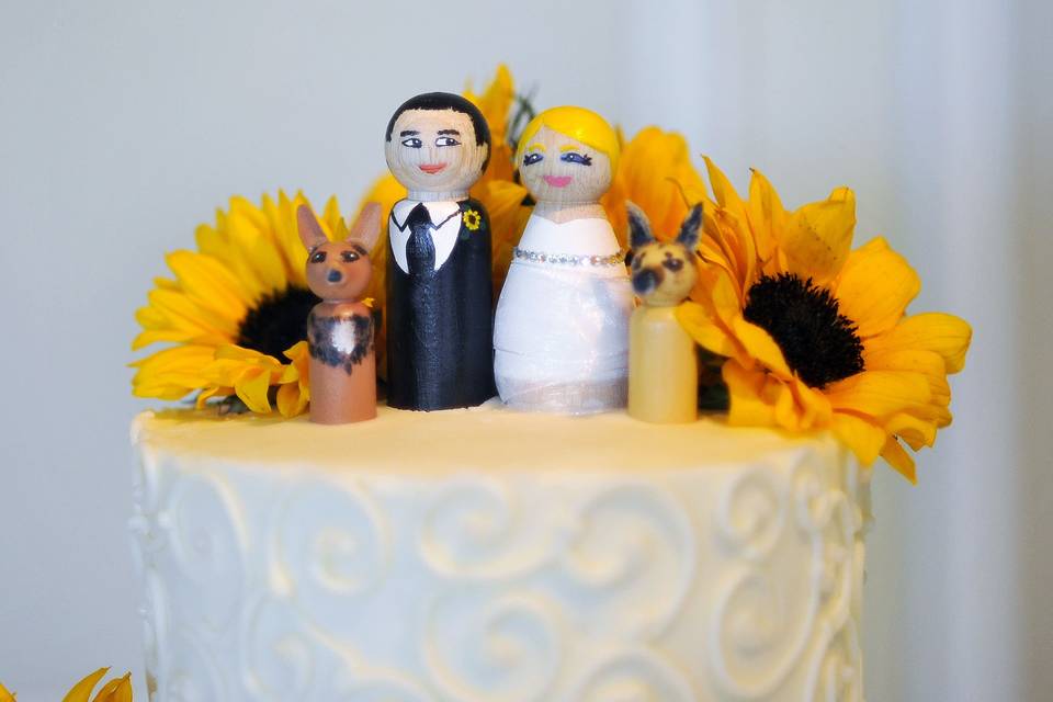 The bride, groom, and their two dogs on top of the cake.