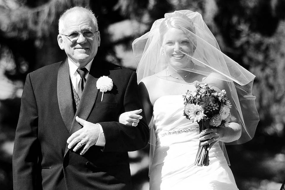 The bride and her father walk down the isle.