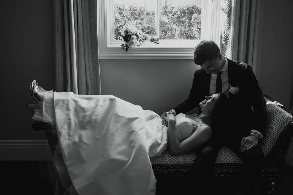 Bride and groom under window