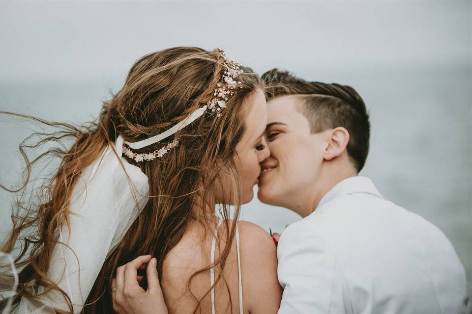 Brides kiss in wind