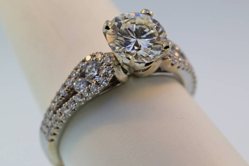 14k white gold diamond engagement ring with graduated side diamonds and a four prong center setting. This is available with any shape or size center stone into this ring. It can also be made in yellow gold or platinum.