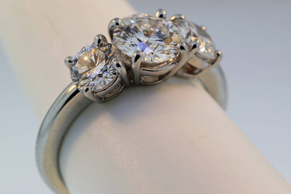 Traditional three stone diamond engagement ring in 14k white gold. This is available with any shape or size center stone into this ring. It can also be made in yellow gold or platinum.