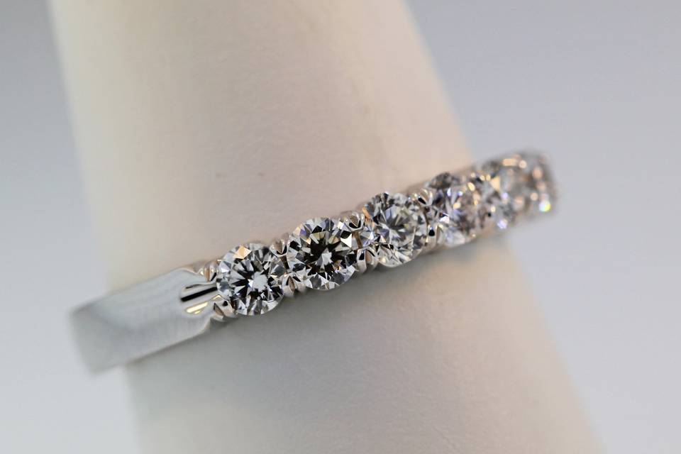 14 karat white gold diamond wedding band with 7 diamonds set in shared prongs. Total weight of .69 carats. $3,800.00