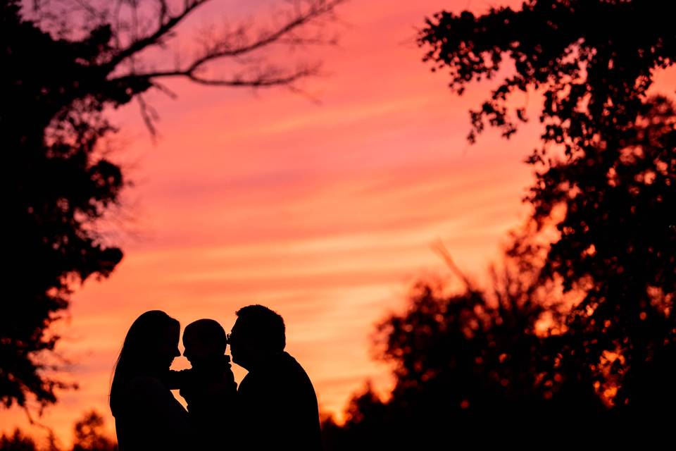 Couple, son snuggle at sunset