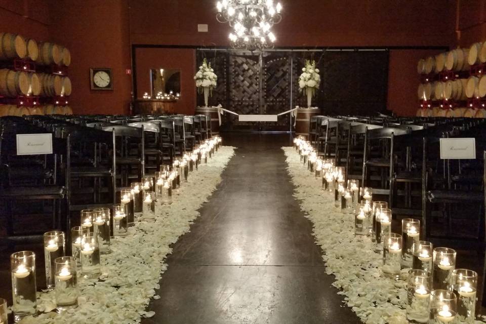 Palm Event Center wine cave, lit with clusters of cylinder vases, floating candles and white petals.