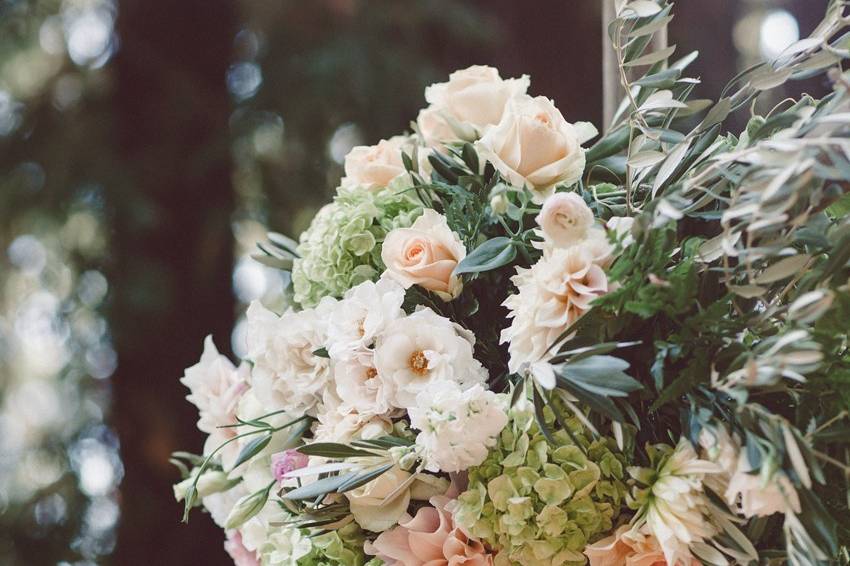 Wedding arbor floral in blush, white, soft greens.