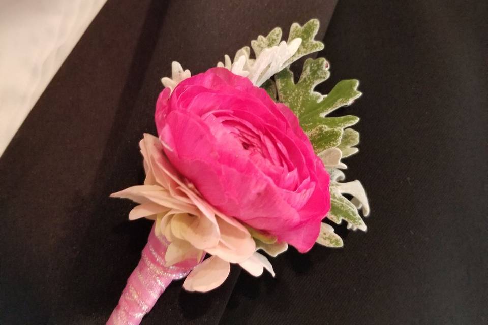 Boutonniere Pink ranunculus with dusty miller and hydrangea.