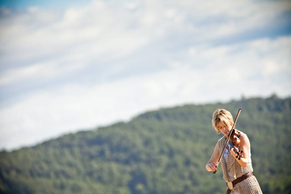 Mountain backdrop behind the violinist