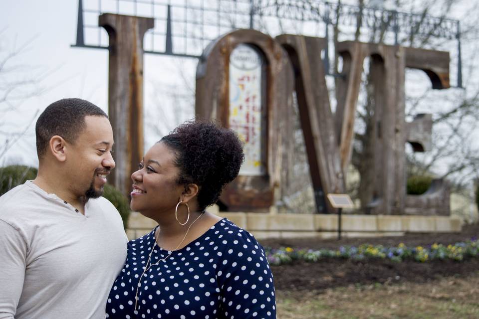 Couple posing in front of love sign