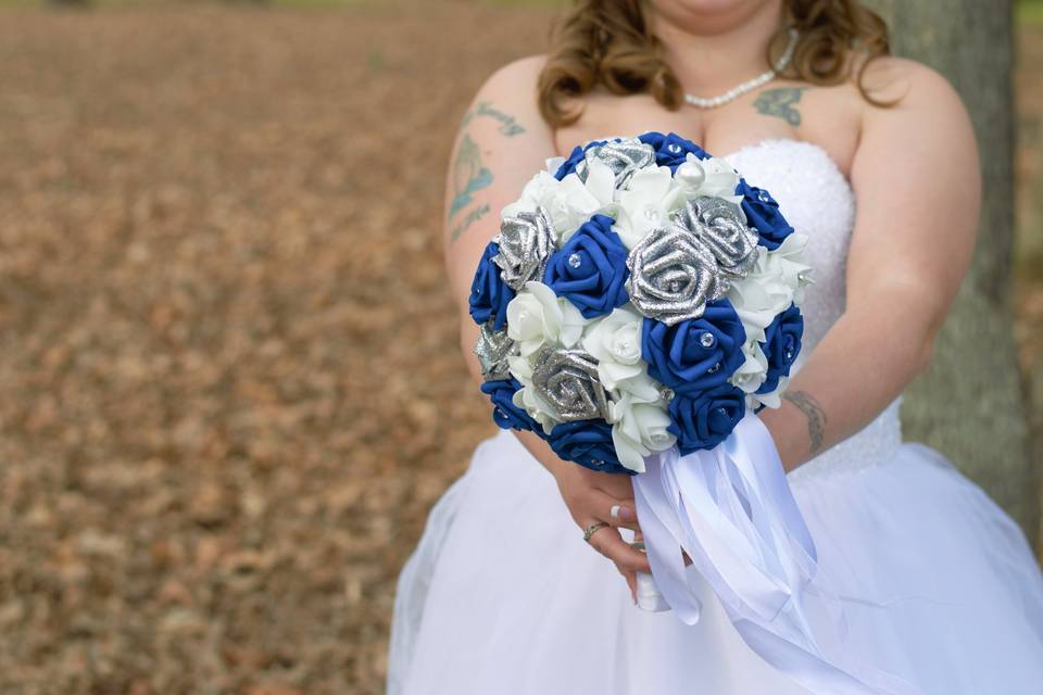 Bride holding blue, white, and silver bouquet