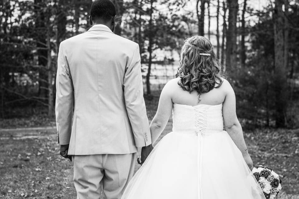 Groom and bride walking in field