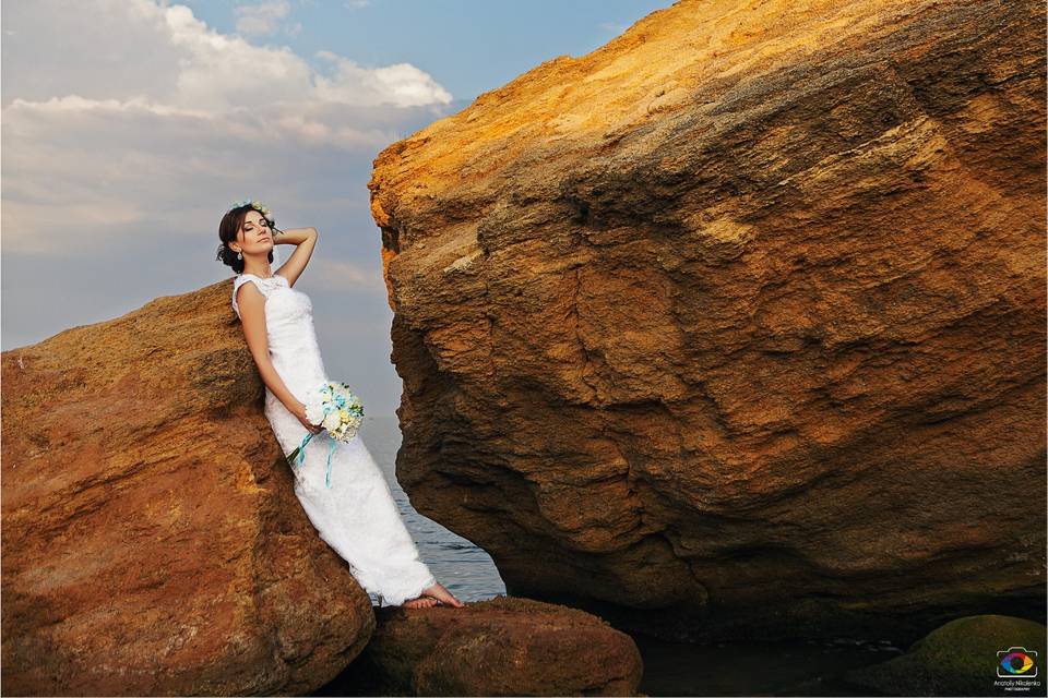 Bride posing beside cliff