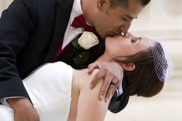 Groom dips his bride for a kiss