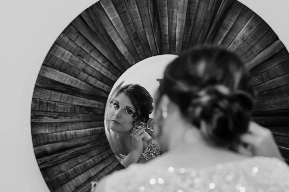 Bride putting on earrings