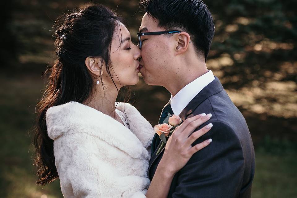 Bride and groom kiss outside