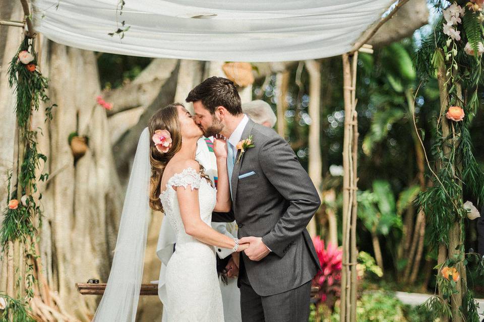 Couple kissing beneath arbor