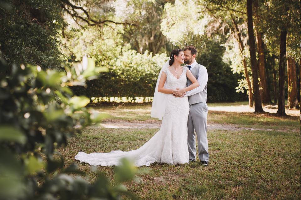 A newlywed embrace surrounded by trees