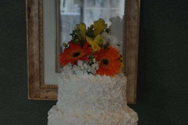 4-tier white wedding cake with floral topper