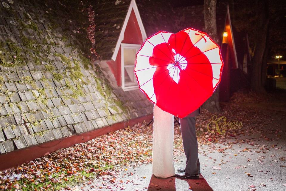 Newlyweds behind a heart-shaped parasol
