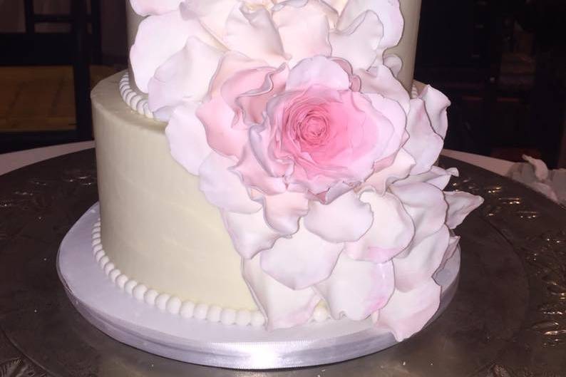 Three tier wedding cake with large pink flowers