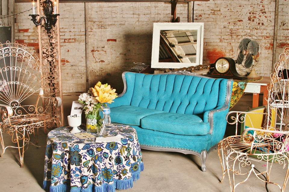 seating arrangement- teal vintage settee, white iron Peacock chairs for event in a downtown garage space