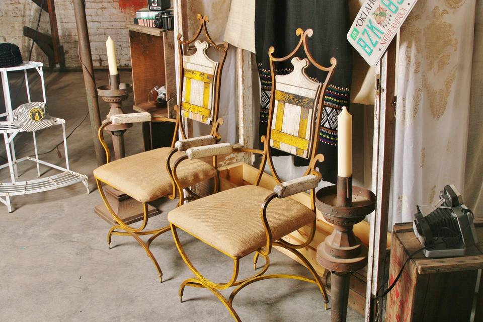 open air photo booth decor- French iron arm chairs, metal floor candle sticks, old cameras