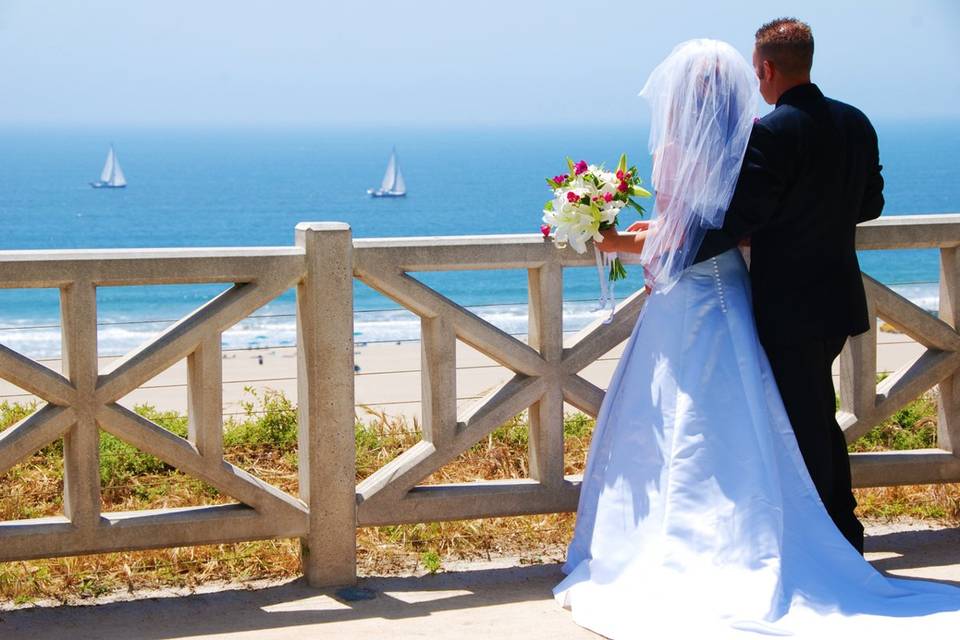 A young couple looking out to the ocean on the Santa Monica Bluff.
