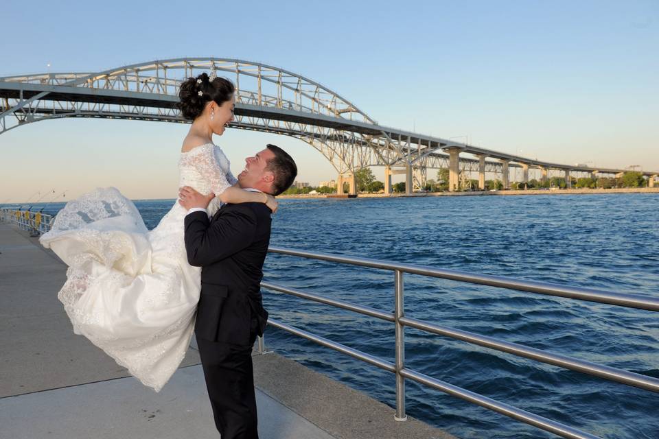 Downtown Port Huron, Michigan wedding couple play on the boardwalk.