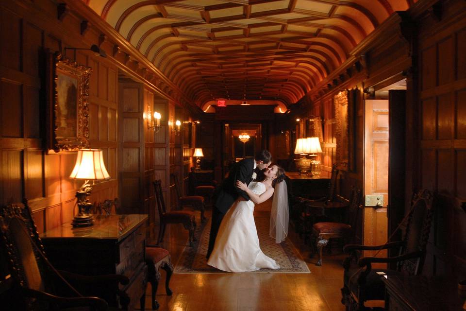 The bride and groom dip in the hallway of the historic Meadowbrook hall in Rochester, Michigan.