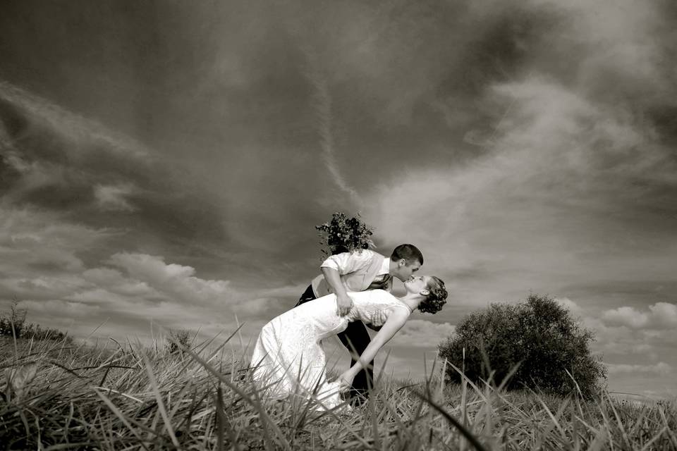 The bride and groom in a dramatic poses after their Michigan farm wedding.