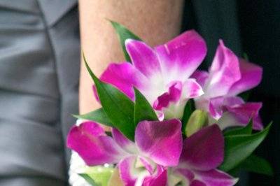 A beautiful, colorful wrist corsage made out of dendrobium orchids on a pearl bracelet wristlet.
