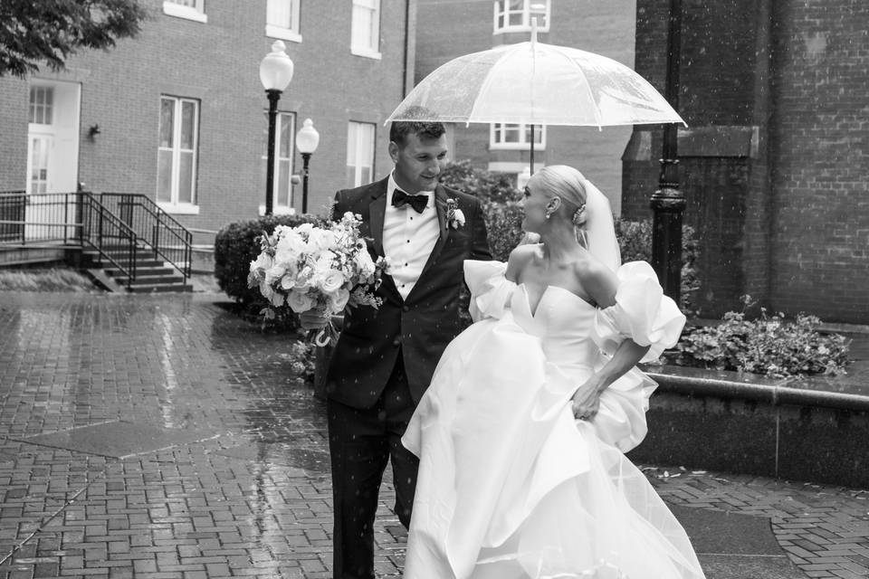 Bride and groom walk in rain