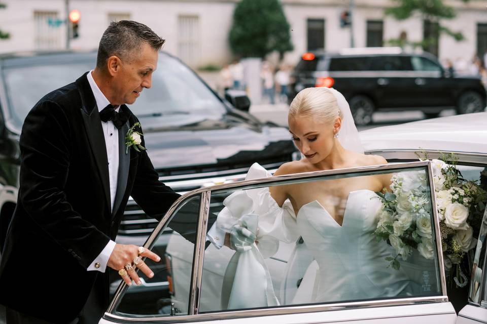 Father helps bride into car