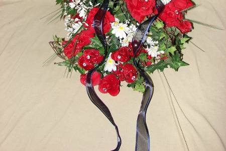 This is my  cascade bouquet of red roses, white daisies, english ivy and red, and blue hand made ribbons.