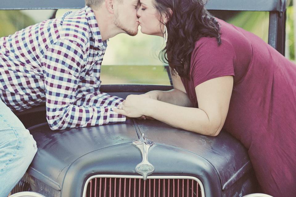A kiss over a vintage car