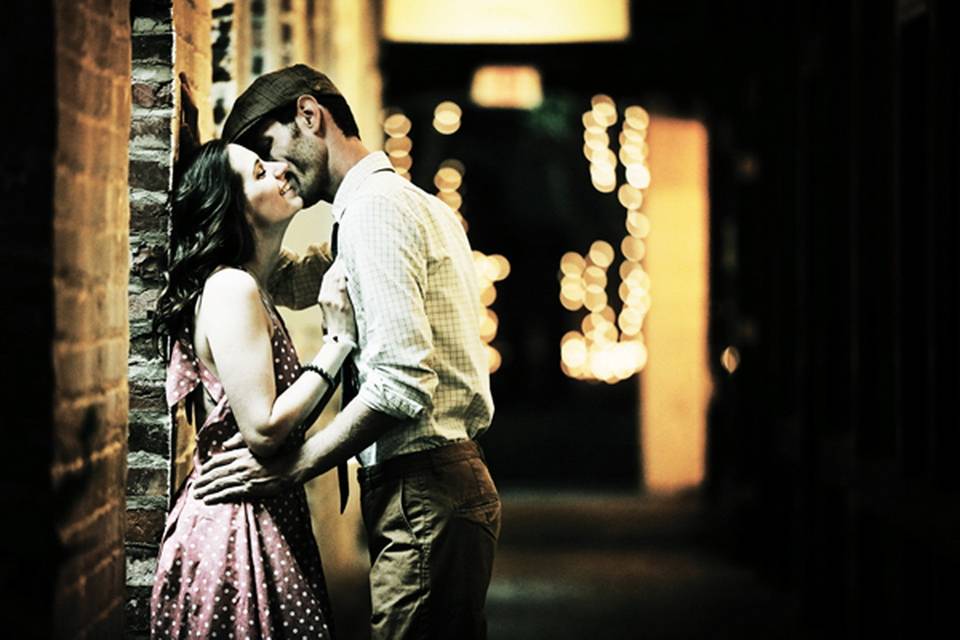 Couple kiss near a brick wall