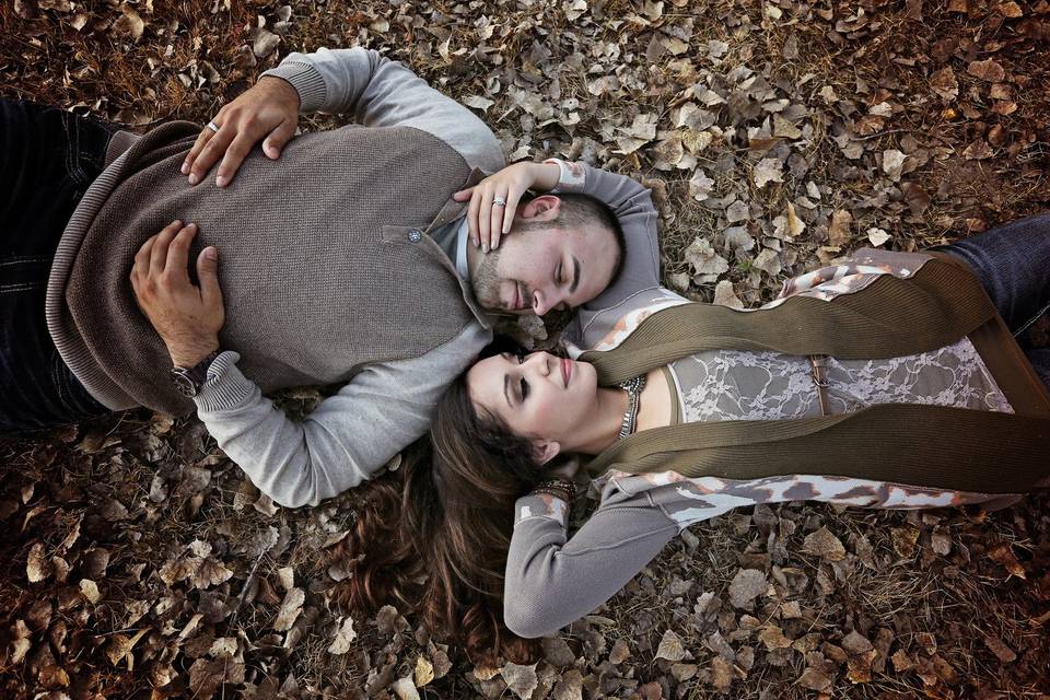 Couple lay on fallen leaves