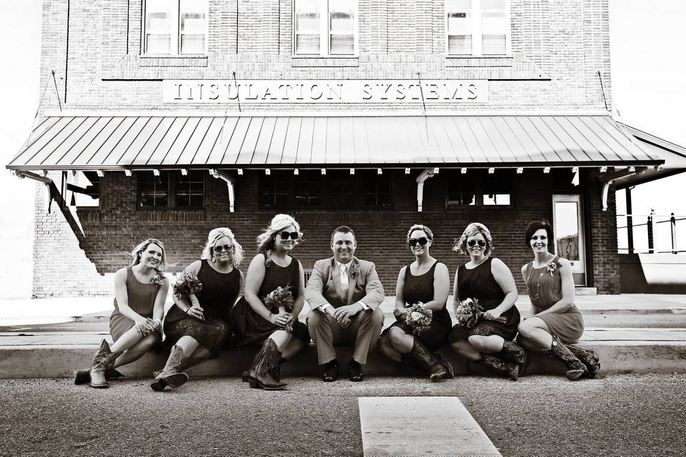 Wedding party seated outside rustic building