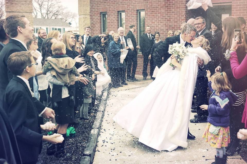 Couple kiss to the joy of their guests