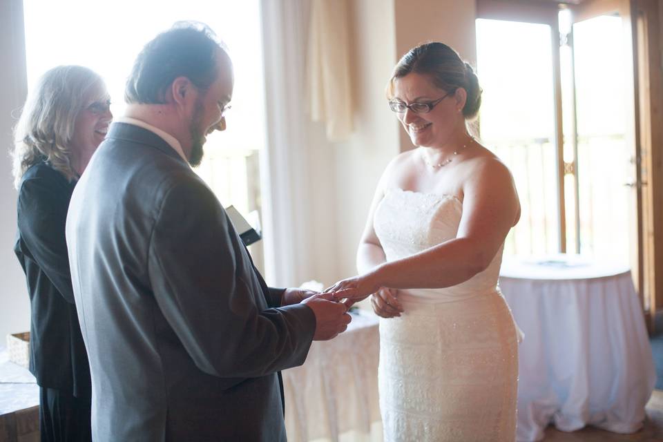 Groom putting a ring on his bride