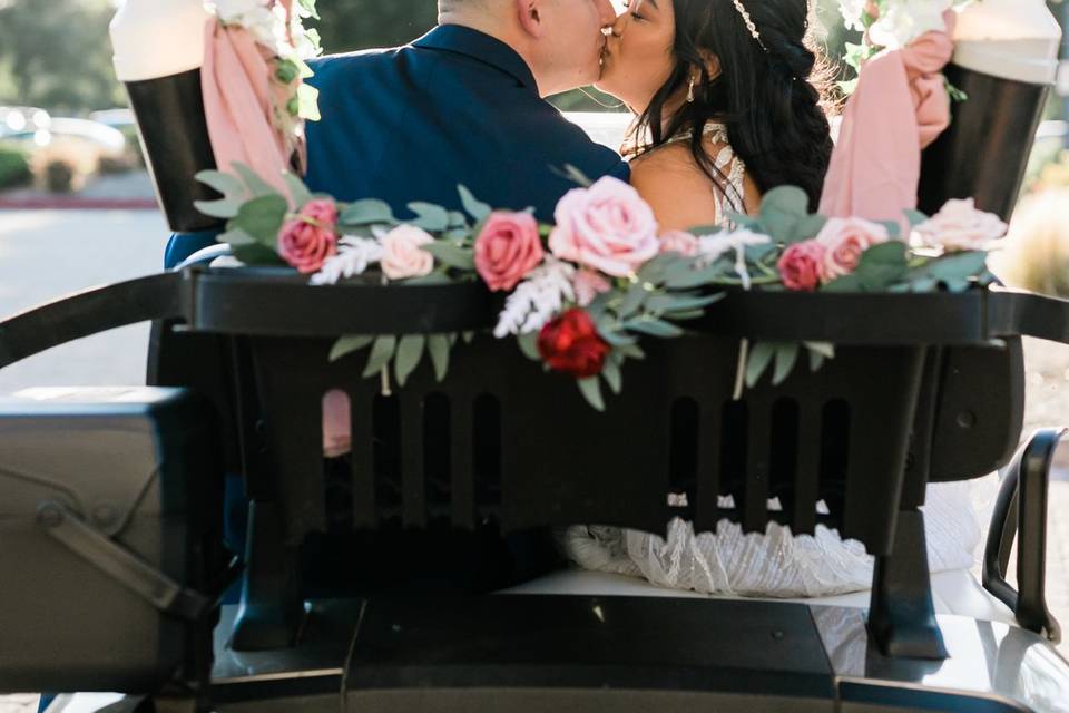 Bride & groom kissing on cart