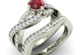 Entwined bands of precious 14k White Gold ornamented with diamonds, securely hold the gorgeous gemstone at the center of this uniquely designed Ruby engagement ring. The matching wedding band perfectly completes the set