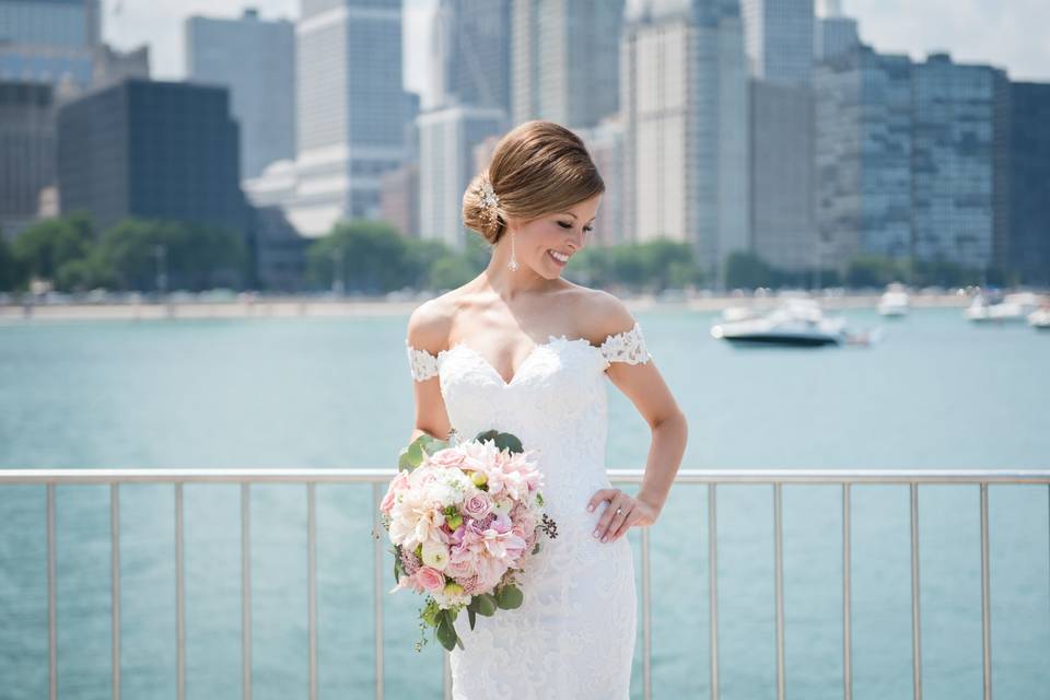 Bride posing beside bay