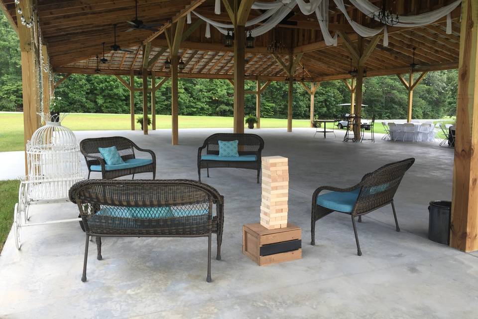 Four brown wicker benches with removable cushions. White metal carriage for gifts or cards.