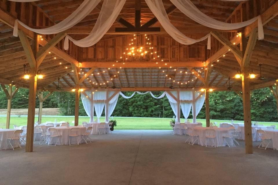 Carriage wheel and white sheers hanging from center of pavilion barn. Carriage Trail Farm