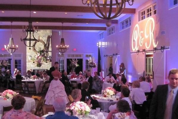 Our pinspots lit all of the tables at this wedding, and the happy couple's initials brightened above their head table in this modern-rustic room.