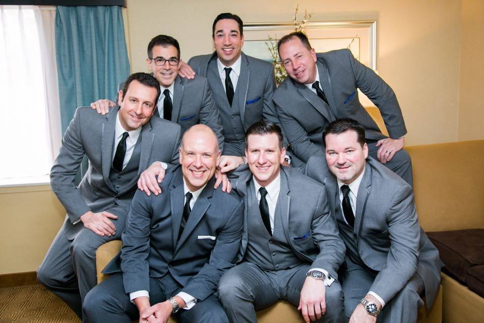 Groom and groomsmen with matching three-piece suits