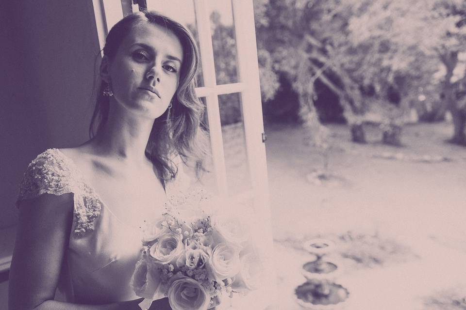 Black and white photo of bride holding bouquet in a window, Montecito CA.