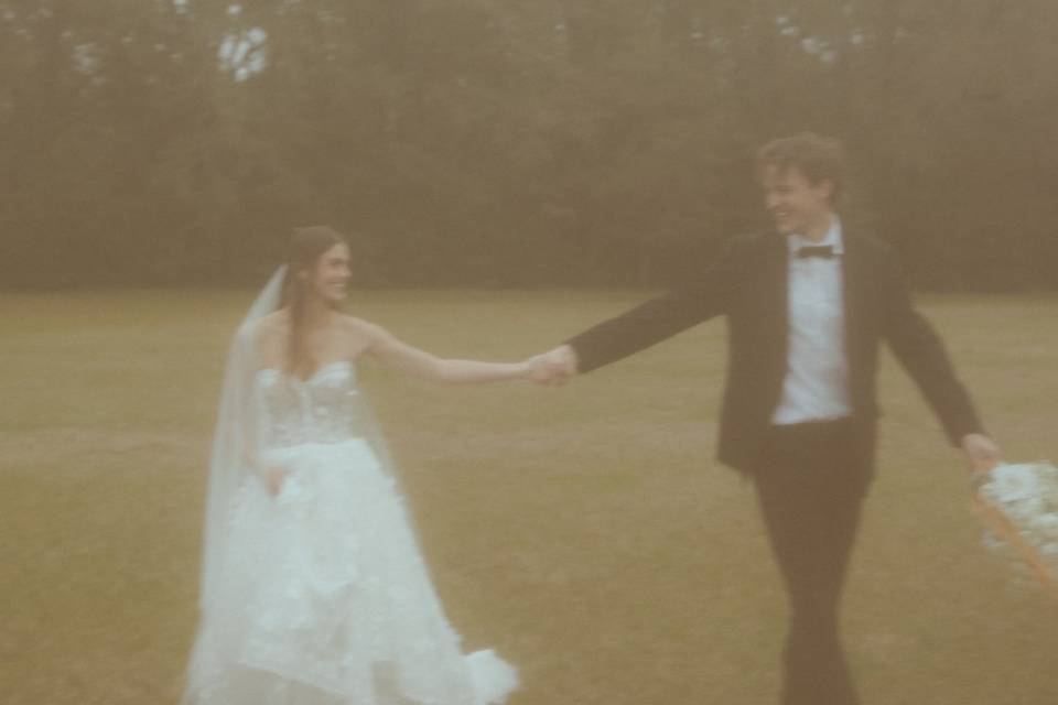 Bride & groom dancing in field