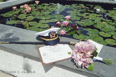 All the elements of the day beside the lily pond at the Ceresville Mansion...the groom's uniform hat and sabre, the bride's bouquet, the ceremony booklet, and the marriage certificate.